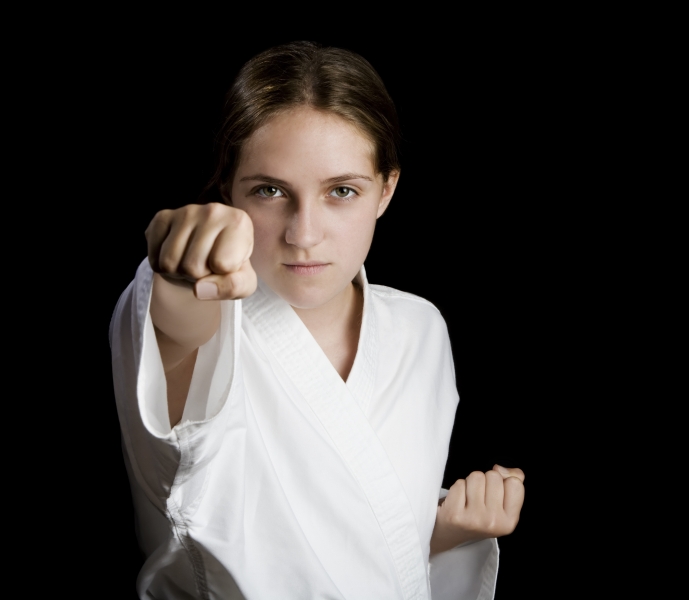 384015-pretty-young-girl-in-a-karate-pose-on-black-background